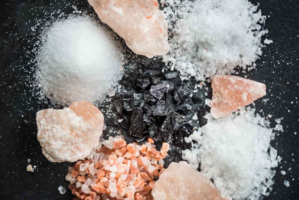 Verschiedene Salze auf schwarzem Stein